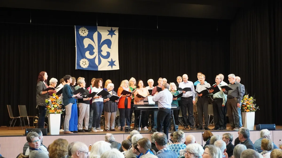 Ein Chor steht auf einer Bühne.